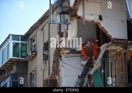 Huludao, Chinas Liaoning Provinz. 12. Juni 2015. Retter arbeiten an der Unfallstelle, wo in Huludao Stadt, Nordost-China Liaoning Provinz, 12. Juni 2015 eine Explosion stattfand. Eine Person starb und zwei weitere werden vermisst, nachdem eine Explosion eines Wohnhauses am Freitagmorgen in Huludao zerriss. Neun Bewohner wurden aus den Trümmern gerettet und ein Dutzend Verletzte, darunter drei Fußgänger, wurde ins Krankenhaus eingeliefert. Die Explosion war vermutet worden, durch verflüssigtes Gas-Leck verursacht werden. © Pan Yulong/Xinhua/Alamy Live-Nachrichten Stockfoto