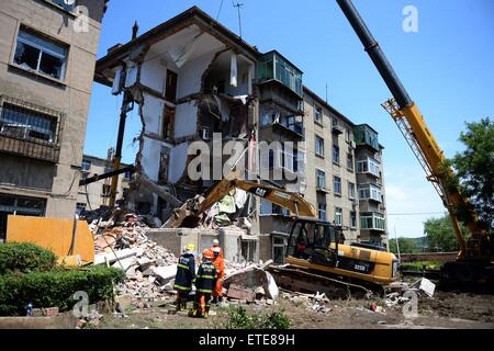 Huludao, Chinas Liaoning Provinz. 12. Juni 2015. Retter arbeiten an der Unfallstelle, wo in Huludao Stadt, Nordost-China Liaoning Provinz, 12. Juni 2015 eine Explosion stattfand. Eine Person starb und zwei weitere werden vermisst, nachdem eine Explosion eines Wohnhauses am Freitagmorgen in Huludao zerriss. Neun Bewohner wurden aus den Trümmern gerettet und ein Dutzend Verletzte, darunter drei Fußgänger, wurde ins Krankenhaus eingeliefert. Die Explosion war vermutet worden, durch verflüssigtes Gas-Leck verursacht werden. © Pan Yulong/Xinhua/Alamy Live-Nachrichten Stockfoto