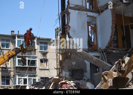 Huludao, Chinas Liaoning Provinz. 12. Juni 2015. Retter arbeiten an der Unfallstelle, wo in Huludao Stadt, Nordost-China Liaoning Provinz, 12. Juni 2015 eine Explosion stattfand. Eine Person starb und zwei weitere werden vermisst, nachdem eine Explosion eines Wohnhauses am Freitagmorgen in Huludao zerriss. Neun Bewohner wurden aus den Trümmern gerettet und ein Dutzend Verletzte, darunter drei Fußgänger, wurde ins Krankenhaus eingeliefert. Die Explosion war vermutet worden, durch verflüssigtes Gas-Leck verursacht werden. © Pan Yulong/Xinhua/Alamy Live-Nachrichten Stockfoto