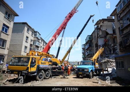 Huludao, Chinas Liaoning Provinz. 12. Juni 2015. Retter arbeiten an der Unfallstelle, wo in Huludao Stadt, Nordost-China Liaoning Provinz, 12. Juni 2015 eine Explosion stattfand. Eine Person starb und zwei weitere werden vermisst, nachdem eine Explosion eines Wohnhauses am Freitagmorgen in Huludao zerriss. Neun Bewohner wurden aus den Trümmern gerettet und ein Dutzend Verletzte, darunter drei Fußgänger, wurde ins Krankenhaus eingeliefert. Die Explosion war vermutet worden, durch verflüssigtes Gas-Leck verursacht werden. © Pan Yulong/Xinhua/Alamy Live-Nachrichten Stockfoto