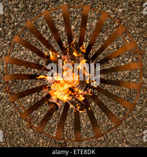 Holzofen im rostigem Metall Feuerschale an einem Sommerabend Stockfoto