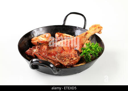 Gebratene Entenkeule und Zwiebel in einer Pfanne Stockfoto