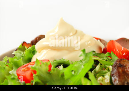 Pfanne gebratene Hühnerleber mit Salat und Speckstreifen Stockfoto