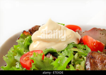 Pfanne gebratene Hühnerleber mit Salat und Speckstreifen Stockfoto