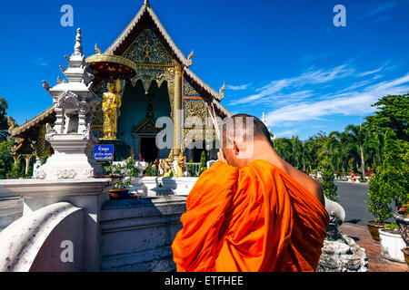 Asien. Thailand, Chiang Mai. Wat Phra Singh. Mönch beten vor der goldenen Statue eines verehrten Mönchs. Stockfoto