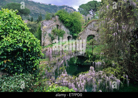 Glyzinien deckt eine alte Brücke über den Fluss Ninfa in der zentralen italienischen Garten Ninfa, südlich von Rom. Stockfoto