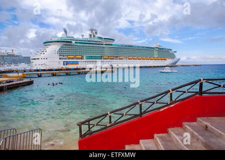 Liberty-Klasse Luxus-Kreuzfahrtschiff, Liberty of the Seas im Hafen angedockt am Hafen in Cozumel, Mexiko. Passagiere Fuß am Dock. Stockfoto