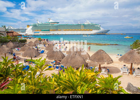 Freiheit der Meere Kreuzfahrtschiff auf Cozumel, Mexiko angedockt. Touristen, Schwimmen und relaxen am Strand unter Cabanas. Stockfoto