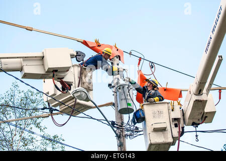 Zwei Linemen für New Hampshire Electric Cooperative Inc. reparieren elektrische Drähte mit Cherry Pickers, erhöhte Arbeitsbühnen. Stockfoto