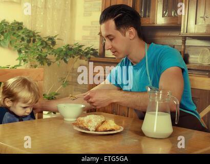 Mann mit kleinen Jungen in der Küche eine Mahlzeit zuzubereiten. Retro Stockfoto