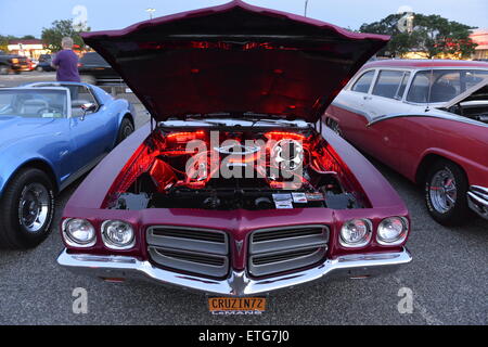 New York, USA. 12. Juni 2015. Unter einer offenen Haube ist der Motor des roten Cabrio 1972 Pontiac Le Mans Sport in rot auf der Freitag Nacht Auto Show statt in Bellmore Long Island Railroad Station Parkplatz beleuchtet. Hunderte von klassischen, antiken und kundenspezifische Autos wurden in die kostenlose wöchentliche Show, gesponsert von der Handelskammer von der Bellmores zu sehen. Stockfoto
