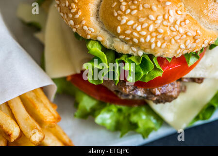 Nahaufnahme von hausgemachten Burger mit frischem Gemüse und Pommes frites Stockfoto