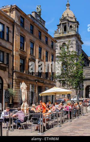 Menschen Essen unter freiem Himmel im italienischen Viertel, John Street von Glasgow mit der City Chambers im Hintergrund, Glasgow, Stockfoto