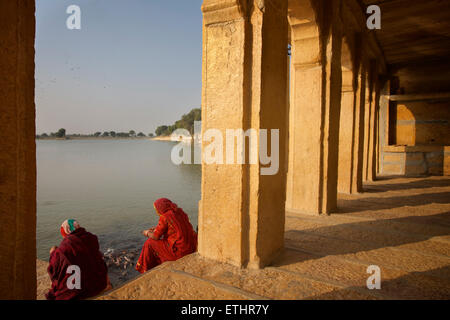 Indische Frauen in Saris Fütterung Wels bei Gadi Sagar, Gadisar See, Jaisalmer, Rajasthan, Indien Stockfoto