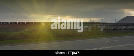 Güterzug auf Sonnenuntergang Strahl vorbei Stockfoto