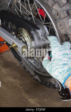 Enduro Motorrad Kette schmieren Spray Schmiermittel erschossen Closeup Stockfoto