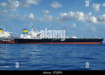 Rohöl-Tanker lädt im Hafen auf dem Hintergrund der Wolken Stockfoto