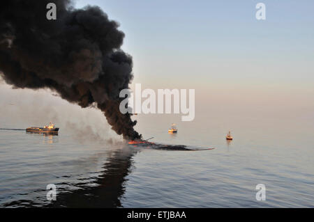 Dunkle Wolken füllen den Himmel so aufräumen Besatzungen Verhalten kontrolliert verbrennt Öl von der Oberfläche des Golfs von Mexiko nach der BP Deepwater Horizon Öl gesammelt zu Katastrophe verschütten als Bemühungen zur Eindämmung und reinigen Sie die Millionen von Gallonen Crew weiter 6. Mai 2010 im Golf von Mexiko. Stockfoto