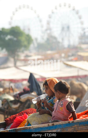 Indische Kinder auf einem Wagen bei der Pushkar Camel fair, Rajasthan, Indien Stockfoto