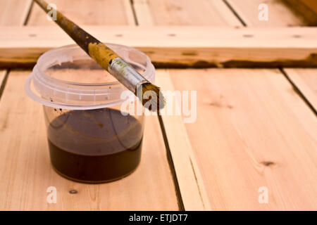 Glas mit Naturwasser Tönung und Farbe Pinsel über eine hölzerne Tür nur nach dem Schleifen Stockfoto