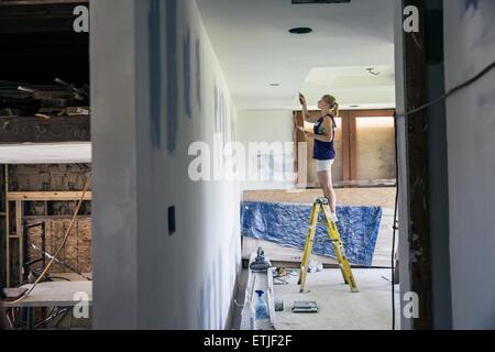 (150614)--NEW ORLEANS, 14. Juni 2015 (Xinhua)--Felicitas Peil, eine 20-Jahr-alte deutsche Freiwillige, malt das Innere eines neu gebauten Hauses in Lower Ninth Ward, New Orleans, Louisiana, USA, 10. Juni 2015. Seit Sommer 2005 ist der Lower Ninth Ward ein Abladeplatz für unerwünschte Dinge geworden. Wildgras bis Erwachsenengröße herrscht in der Gegend, unter denen die Wracks von verlassenen Häusern bedrohlich stehen. Zehn Jahre nach dem Hurrikan Katrina hat New Orleans in die Knie und ließ eine emotionale Präsenz in den Vereinigten Staaten als Menschen erlebt wie die US-Regierung Stockfoto