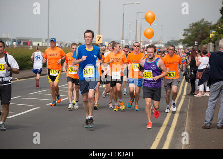 Southend, UK. 14. Juni 2015. Läufer aus "Southend Flyer Running Club" gekleidet in Orange im Gedächtnis von Nick Palmer, 37 aus großen Wakering, die zusammenbrach und starb nach der Überquerung der Ziellinie letztes Jahr.  Dieses Jahre Rennen ging ohne größere Zwischenfälle. Bildnachweis: Graham Eva/Alamy Live-Nachrichten Stockfoto