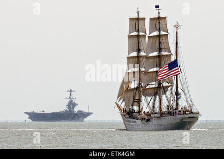 Die US Coast Guard Cutter Eagle hoch Segelschiff fährt vorbei an einem Navy Flugzeugträger in der Chesapeake Bay 8. Juni 2015 in der Nähe von Norfolk, Virginia. Stockfoto