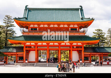 Der Heian-schrein in Kyoto, Japan. Die massive Oten-mon Tor, ein zweigeschossiges Torhaus in Zinnoberrot, Weiß und mit grünen Dächern. Die Menschen in den Vordergrund. Stockfoto