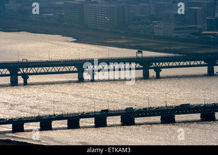 Luftbild vom Umeda Sky Building, Osaka, von Eisenbahn- und Straßenbrücken, die Kyu-Yodo, Yodo, Fluss, bei Sonnenuntergang, goldene Stunde überspannen. Hazy aufgrund von Umweltverschmutzung. Stockfoto