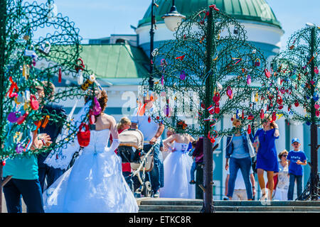 Moskau, Russland. 13. Juni 2015. Heißes Wochenende in Moskau, Russland. Die Temperatur beträgt etwa 27 ° c (80, 6F). Dies ist ziemlich heiß für Moskau. Das heiße Wetter hindert nicht Touristen besuchen roten Platz, aber es gibt nicht viele Leute in den Straßen. Menschen bevorzugen auf der Moskwa oder am Fluss oder in den kühlen Schatten zu bleiben. Am Wochenende ist die Hochzeit Zeit in Moskau. Brautpaar auf Luschkow (Liebhaber) Brücke von Moskau, ein Vorhängeschloss auf ein Bügeleisen zu beheben Baum Credit: Alex Bilder/Alamy Live News Stockfoto