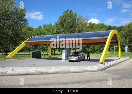 Ein Elektroauto aufgeladen an einem Fastned Elektrofahrzeug Ladestation an einer Autobahnraststätte in den Niederlanden. Stockfoto