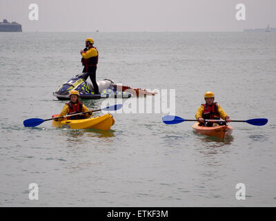 Rettungsschwimmer aus der königlichen Leben sparen Gesellschaft patrouillieren im Meer vor Southsea Strand auf den Jetski und Kajaks bei einem Triathlon auch Stockfoto