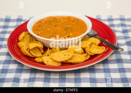 Chicken Tortilla Suppe in Schüssel weiß auf rotem Teller mit Mais-chips Stockfoto