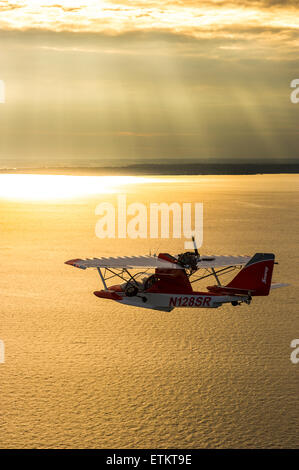 Searey ein kleines Wasserflugzeug fliegen über die Chesapeake-Bucht während eines Sonnenuntergangs in Maryland, USA Stockfoto