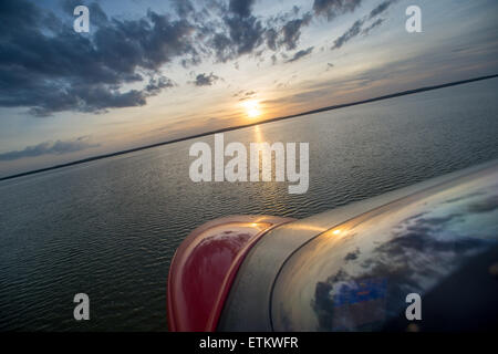 Nase von Wasserflugzeug während des Fluges über Wasser bei Sonnenuntergang im Südosten der USA Stockfoto