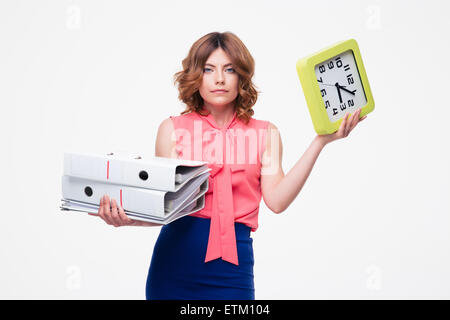 Junge schöne Geschäftsfrau hält Ordner und Clock isoliert auf einem weißen Hintergrund. Blick in die Kamera Stockfoto