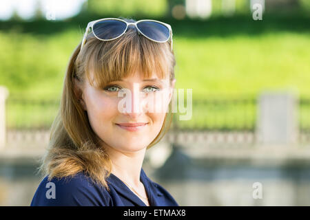 Kaukasische Mädchen mit Sonnenbrille am sonnigen Sommertag im Park. Ziemlich lächelnd kaukasische Mädchen Stockfoto