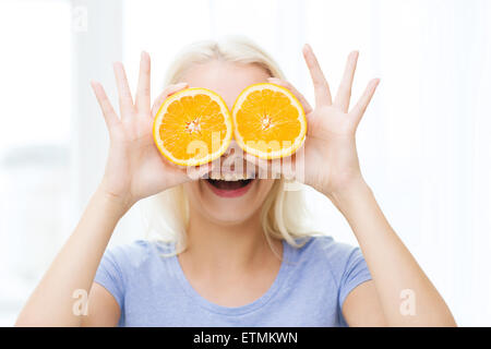 fröhliche Frau, die Spaß für Augen mit Orange Stockfoto