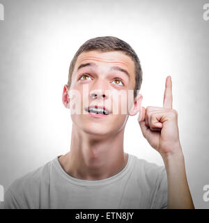 Junger Mann mit Zeigefinger nach oben. Stockfoto