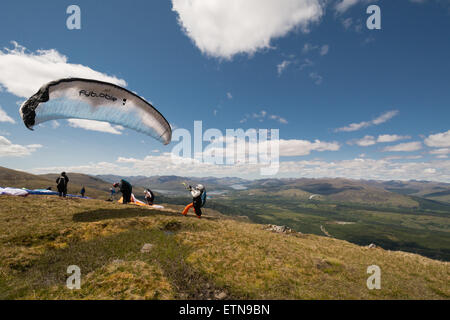 Aonach Mor, Fort William, Schottland, UK: 14. Juni 2015. UK-Wetter.   Einem schönen klaren sonnigen Tag in den schottischen Highlands, mit nur einer ganz leichten Brise.   Gleitschirme von Peak der Sgurr Finnisg-Aig, im oberen Bereich der Nevis Range Gondel, mit herrlichem Blick über Fort William, Loch Linnhe und Great Glen ausziehen wird vorbereitet Stockfoto