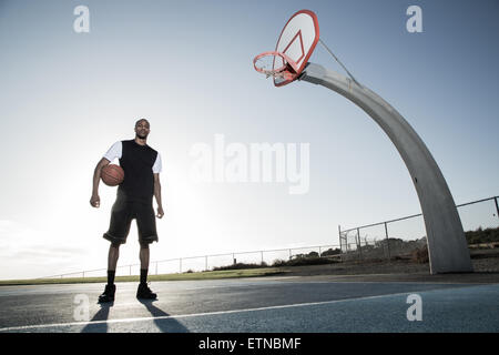 Porträt eines jungen Mannes mit einem Basketball in einem Park, Los Angeles, Kalifornien, USA Stockfoto