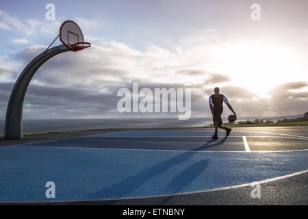 Junger Mann spielen Basketball in einem Park, Los Angeles, Kalifornien, USA Stockfoto