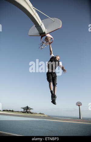 Junger Mann spielen Basketball in einem Park, Los Angeles, Kalifornien, USA Stockfoto