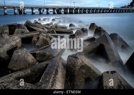 Wellenbrecher und Straße über das Meer unter bewölktem Himmel, Präfektur Kanagawa, Japan Stockfoto