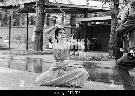 Indische klassische Tänzer, London, 28. August 1965. Tänzerin hält eine Pose für Fotografen als ältere Engländerin blickt auf. Stockfoto