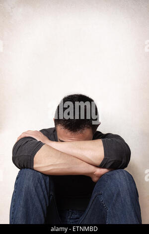 Trauriger junger Mann versteckt sein Gesicht Stockfoto