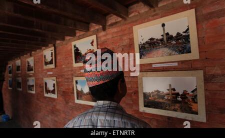 Bhaktapur. 15. Juni 2015. Eine lokale besucht eine Fotoausstellung, die Anzeige der Ortsbilder, vor und nach einem Erdbeben in einem Programm zur Eröffnung der UNESCO-Welterbe des Kathmandu-Tals für Touristen in Bhaktapur Durbar Square in Nepal, 15. Juni 2015. Bildnachweis: Sunil Sharma/Xinhua/Alamy Live-Nachrichten Stockfoto