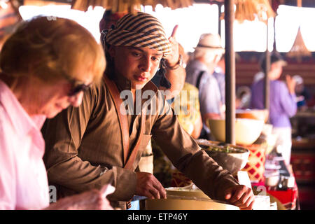 Bedouin arab Boy vorbereiten und servieren im Nahen und Mittleren Osten essen an Touristen an Arabischen camp Wadi Rum Jordanien Naher Osten. Stockfoto