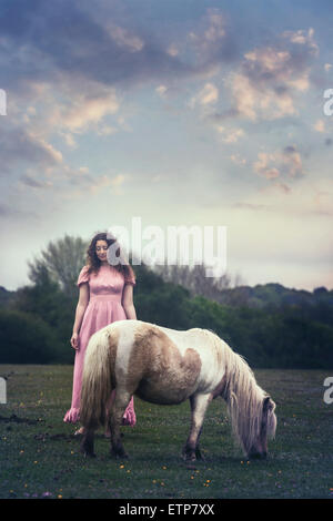 eine Frau mit einem Pony auf einer Koppel Stockfoto