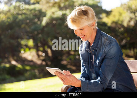 glücklich senior blonde Frau SMS auf Smartphone Stockfoto